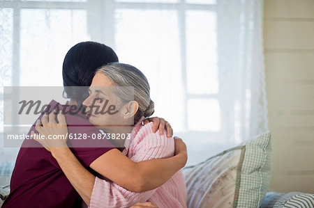 Smiling young nurse comforting an elderly woman. Smiling young nurse comforting an elderly woman.