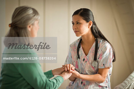 Smiling young nurse comforting a senior woman. Smiling young nurse comforting a senior woman.