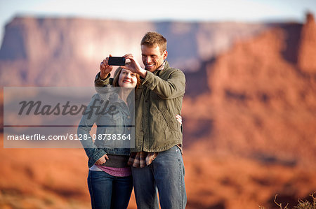 Smiling couple taking a self portrait on a cell phone.
