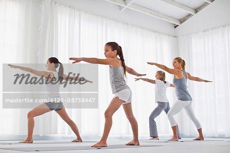 Group of people stretching their arms during a yoga class.