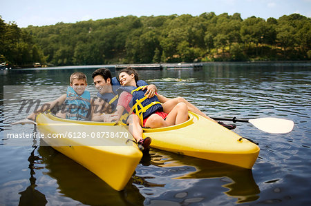 Happy family kayaking on a lake.