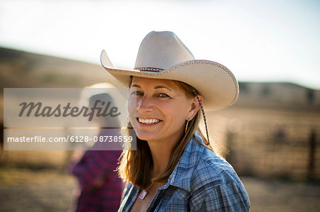 Portrait of a smiling rancher wearing a cowboy hat while out on the ranch.