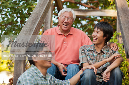 Smiling senior man sitting with his son and grandson.