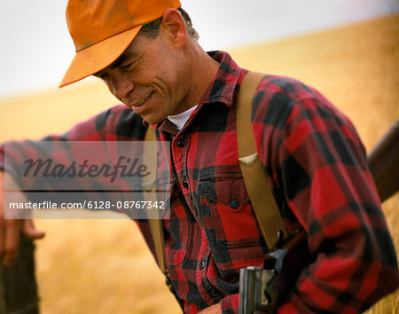 Man in plaid shirt leaning on post