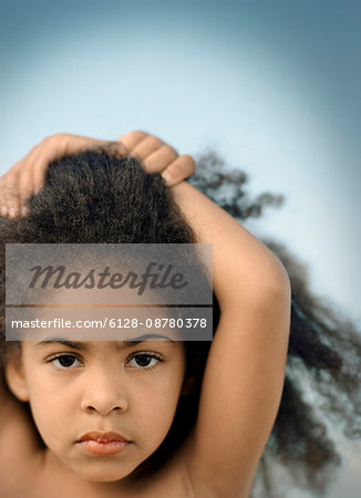 Portrait of a young girl with curly black hair standing with her