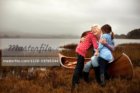 Mature woman hugging her two granddaughters.