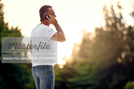 Man talking on his cell phone in a park.