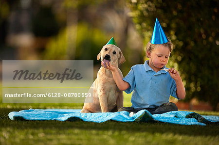 Boy having a picnic with his puppy.