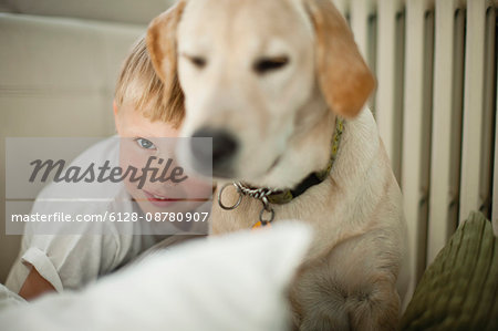 Young boy hugging his dog.