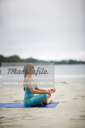 Young woman practicing yoga on a beach Royalty-Free Stock Image