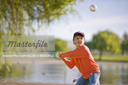 Boy swinging softball bat in park