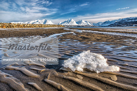 The icy sandy beach surrounding the snow capped mountains Breivikeidet Lyngen Alps Tromsø Lapland Norway Europe