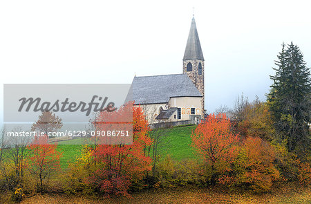 Church of Santa Magdalena in the autumn mist. Funes Valley, South Tyrol, Dolomites, Italy