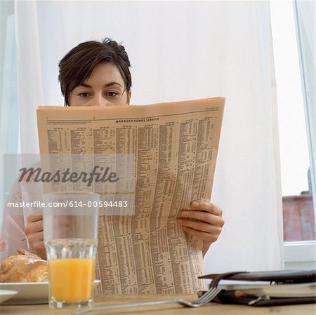 Woman with paper at breakfast