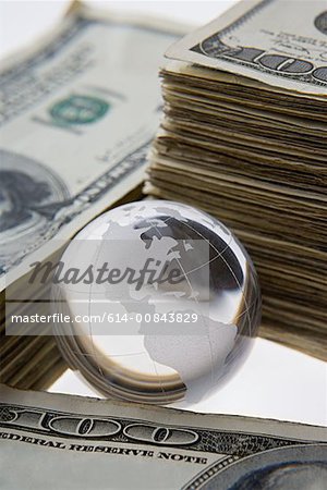 Silver globe and stacks of dollars