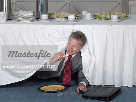 Businessman eating in secret