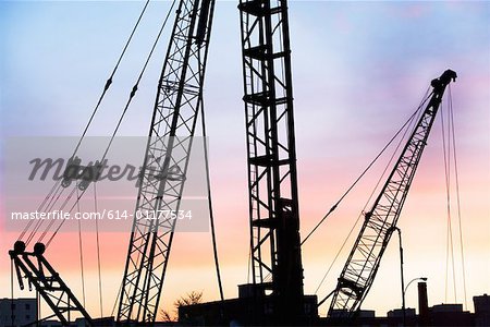 Construction cranes at sunset