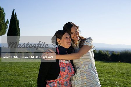 Mother and daughter hugging in a field