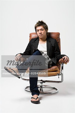 Japanese man sitting on a leather armchair