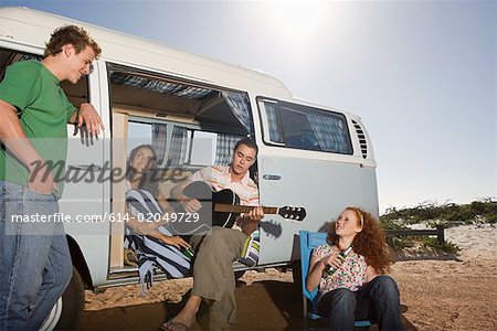 Friends on the beach with a camper van