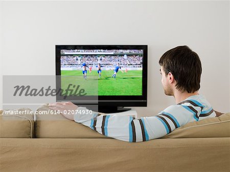A man watching a football match on the tv