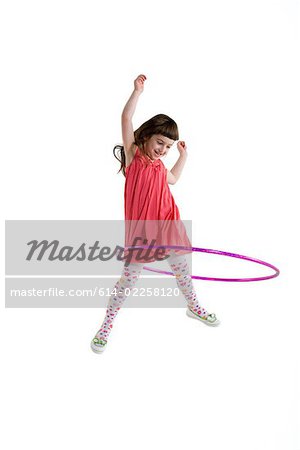 A girl playing with a plastic hoop