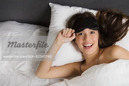 A woman wearing an eye mask in bed