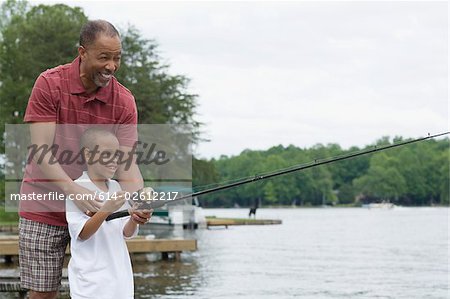 A grandfather teaching his grandson to fish