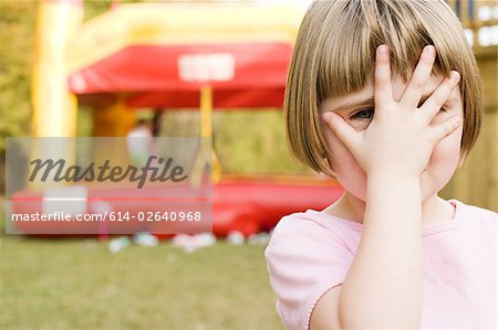 Girl with hand in front of face