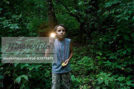 Boy with torch in forest