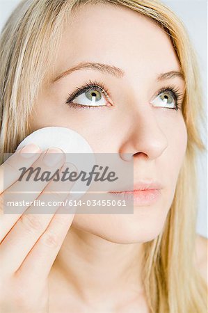 Young woman cleansing face