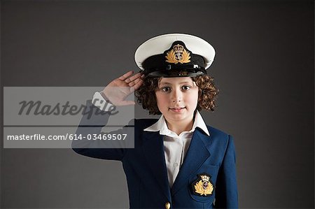 Young boy dressed up in sailor outfit, saluting