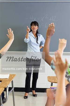 High school students with arms raised in classroom