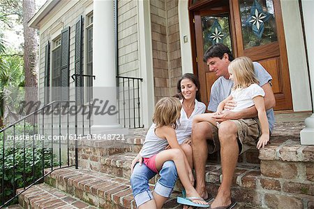 Family sitting on house steps