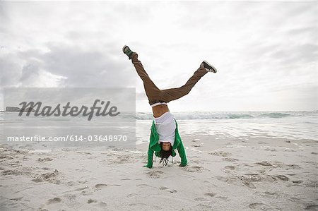 Young man doing cartwheels on beach