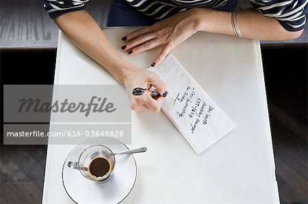 Woman writing note on napkin