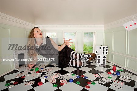 Young woman in small room throwing playing card