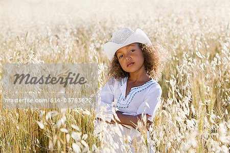 Girl wearing white cowboy hat in field