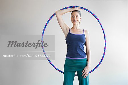 Woman holding plastic hoop doing pilates