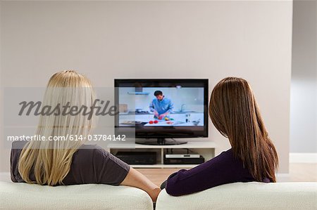 Two young women watching television