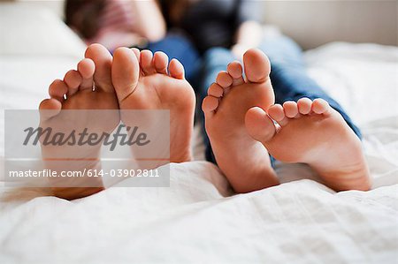 Two teenage girls lying on bed barefoot - Stock Photo - Masterfile -  Premium Royalty-Free, Code: 614-03902811