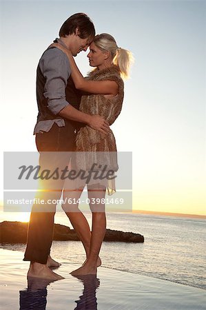 Romantic couple by the ocean at sunset