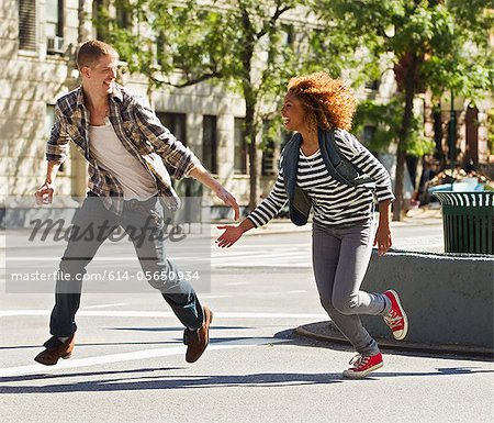 Couple running through city street