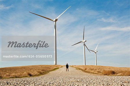 Distant view of man in front of wind turbines