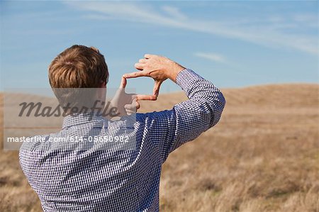 Man using hands to frame landscape