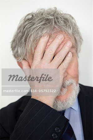 Senior man with hand covering face