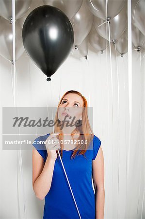 Young woman holding a black balloon