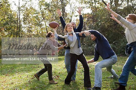 Mature friends playing football