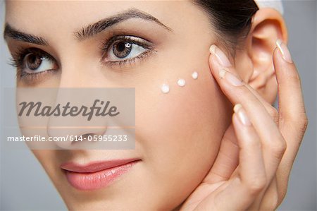 Beautiful woman with cream on her face