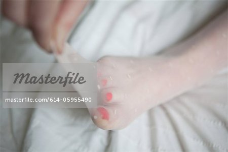 Woman pulling tights away from her toes